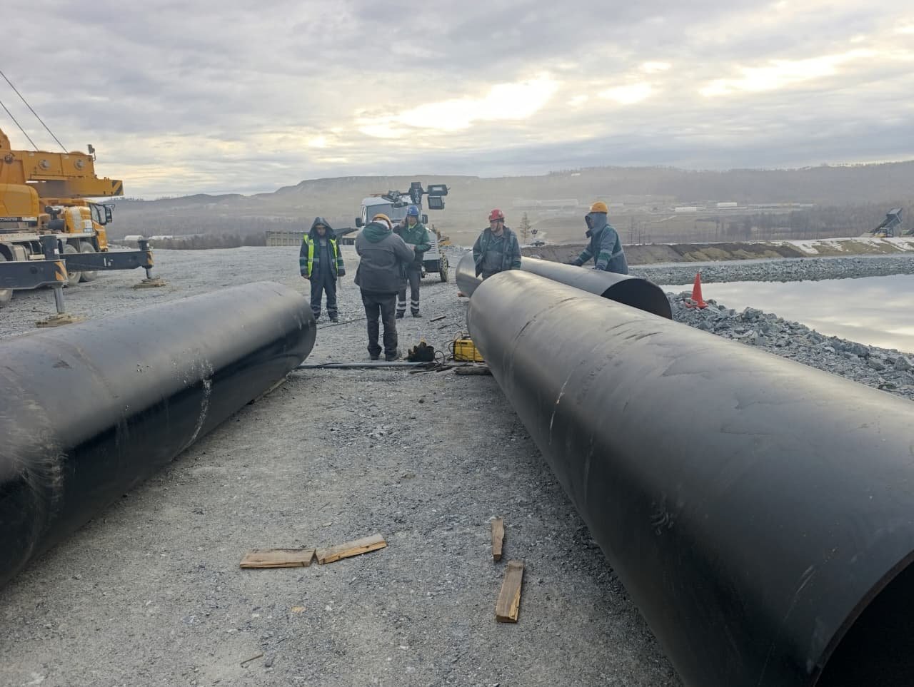 people wokring around large pipes